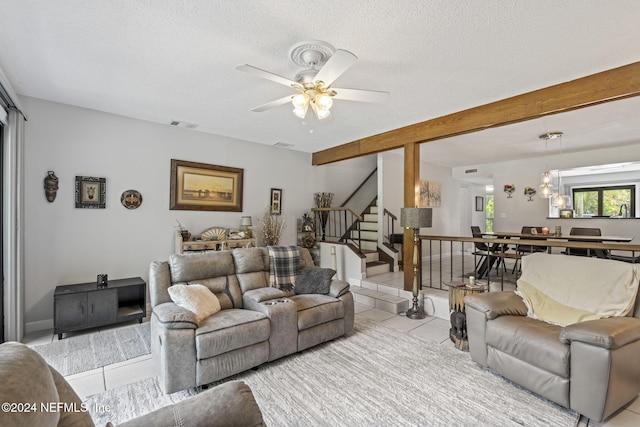 tiled living room with ceiling fan and a textured ceiling