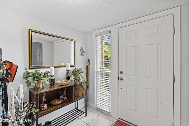 tiled entryway featuring a textured ceiling and electric panel