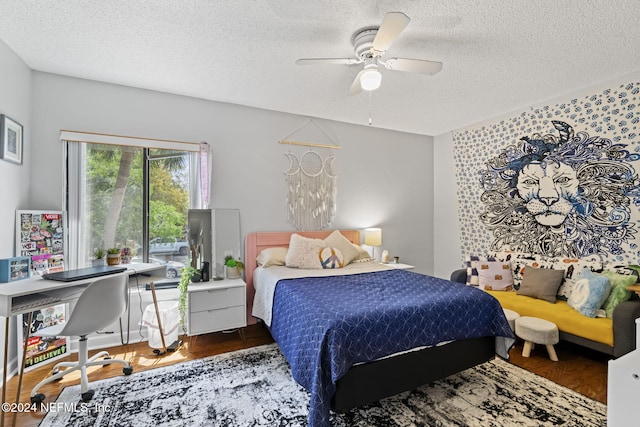 bedroom with ceiling fan, dark wood-type flooring, and a textured ceiling