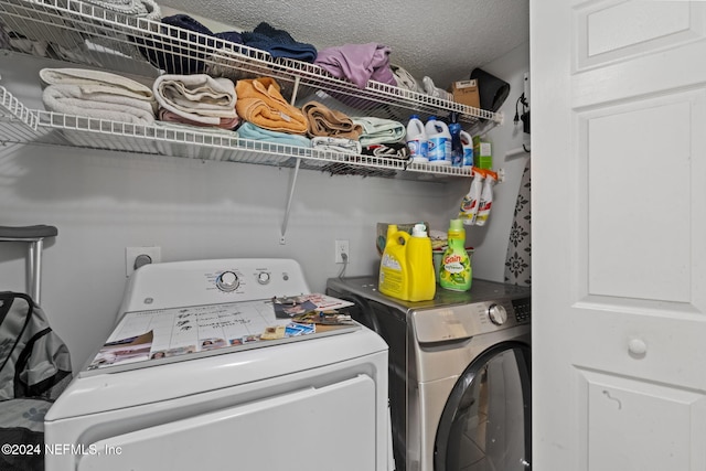 washroom with washer and clothes dryer and a textured ceiling