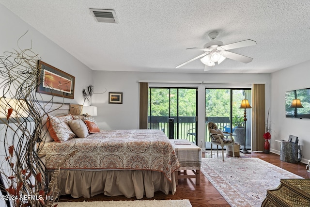 bedroom with access to exterior, a textured ceiling, dark hardwood / wood-style flooring, and ceiling fan