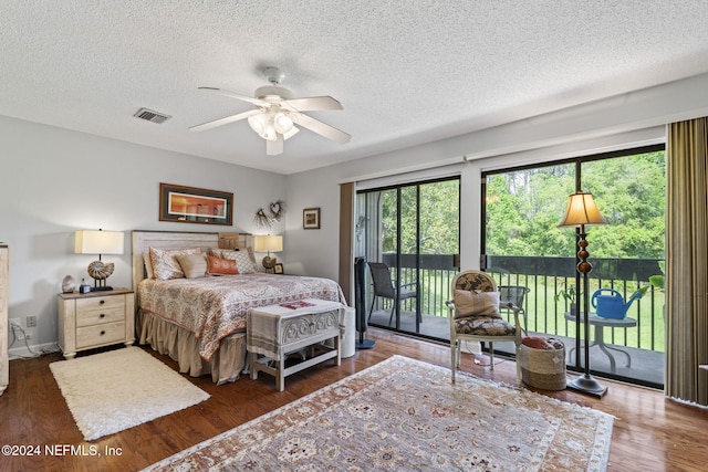 bedroom with access to outside, a textured ceiling, dark hardwood / wood-style floors, and ceiling fan