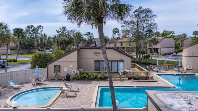 view of pool with a community hot tub, a deck, and a patio