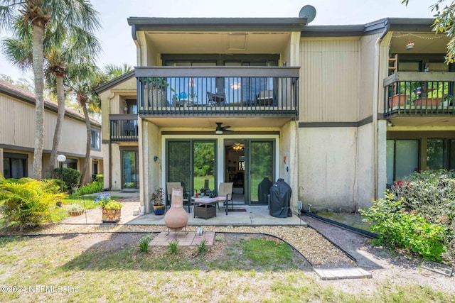 rear view of property featuring ceiling fan, a balcony, and a patio