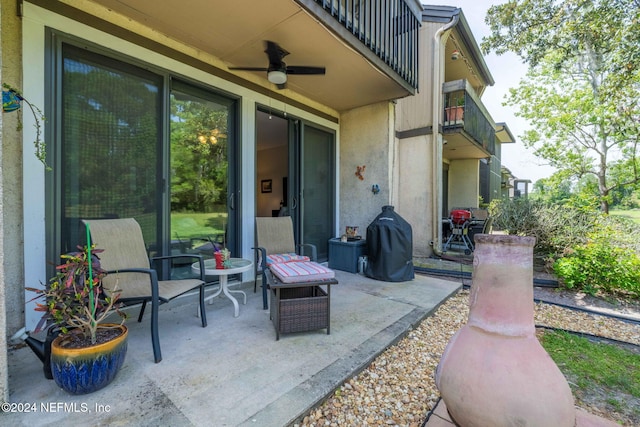 view of patio with ceiling fan and a balcony