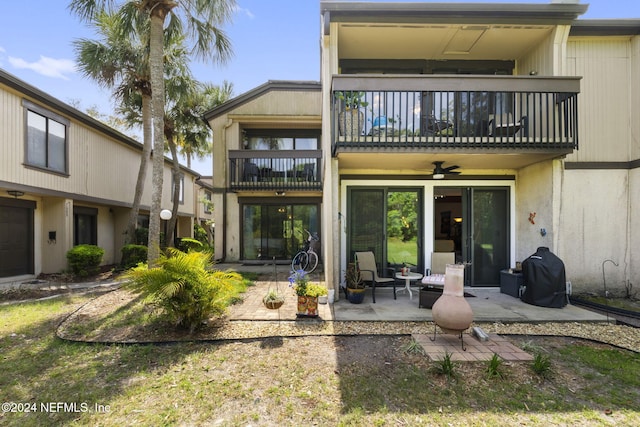 rear view of property with ceiling fan, a balcony, and a patio