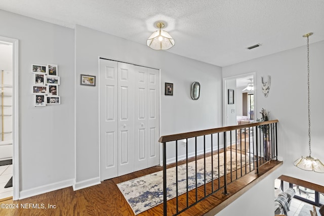 corridor featuring hardwood / wood-style floors and a textured ceiling