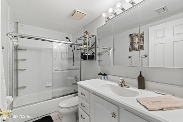 full bathroom featuring tile patterned flooring, vanity, toilet, and bath / shower combo with glass door