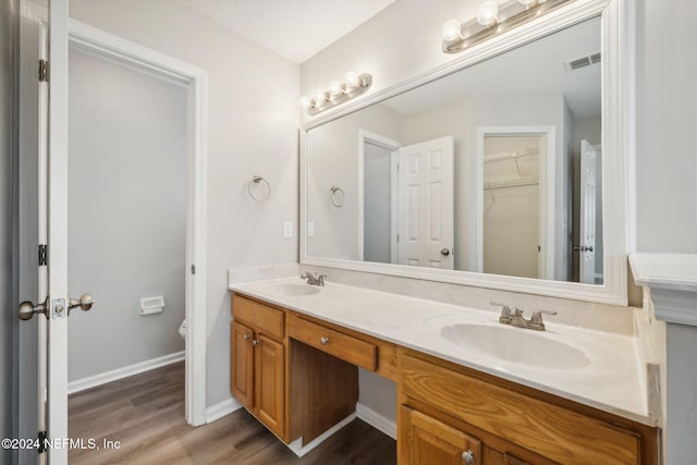 bathroom with hardwood / wood-style floors, vanity, and toilet