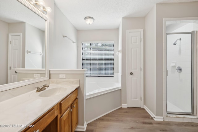 bathroom featuring vanity, plus walk in shower, a textured ceiling, and hardwood / wood-style flooring