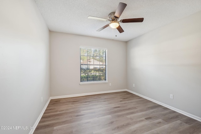 empty room featuring ceiling fan, light hardwood / wood-style flooring, and a textured ceiling