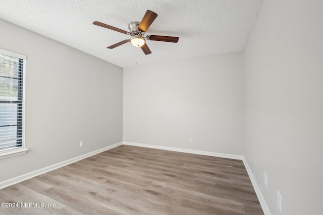 unfurnished room with a textured ceiling, light hardwood / wood-style floors, and ceiling fan