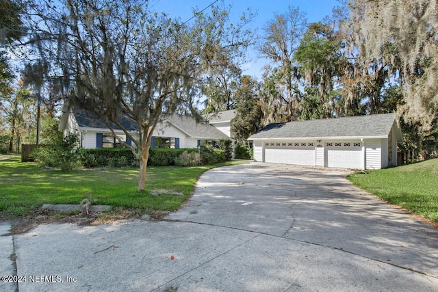 view of front of house with a front yard, a garage, and an outdoor structure