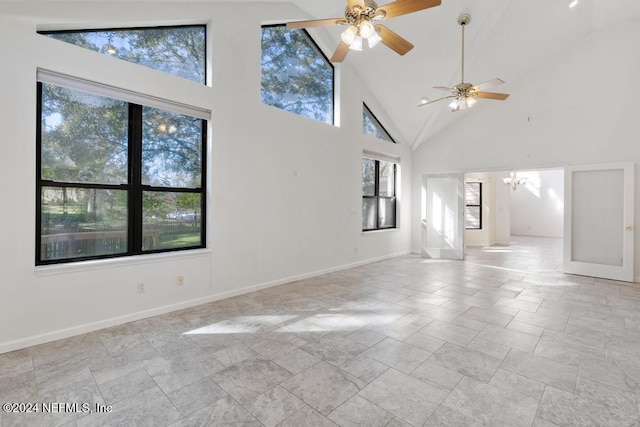 unfurnished living room featuring high vaulted ceiling and ceiling fan with notable chandelier