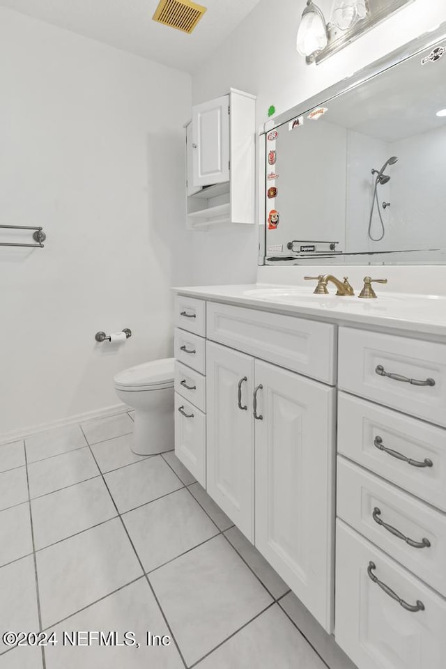 bathroom featuring tile patterned floors, walk in shower, vanity, and toilet