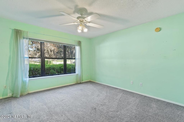 carpeted spare room with ceiling fan and a textured ceiling