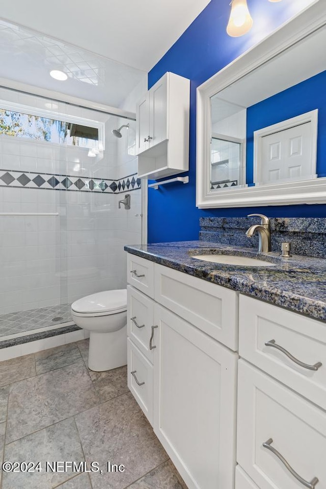 bathroom featuring vanity, toilet, and a shower with shower door