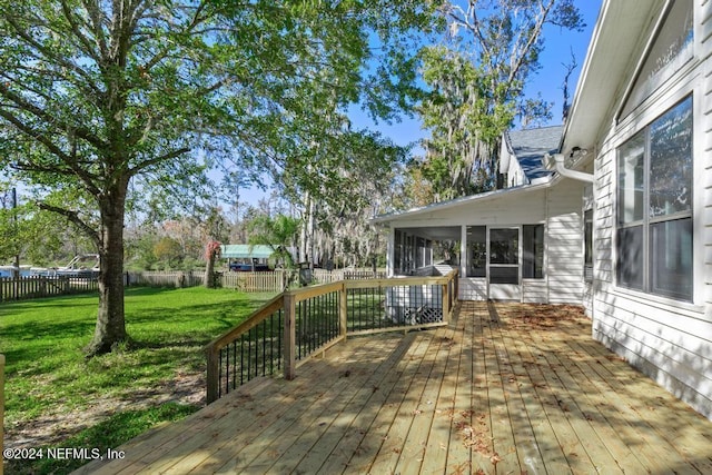 wooden terrace featuring a yard and a sunroom