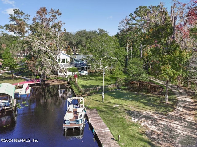 view of dock with a lawn and a water view