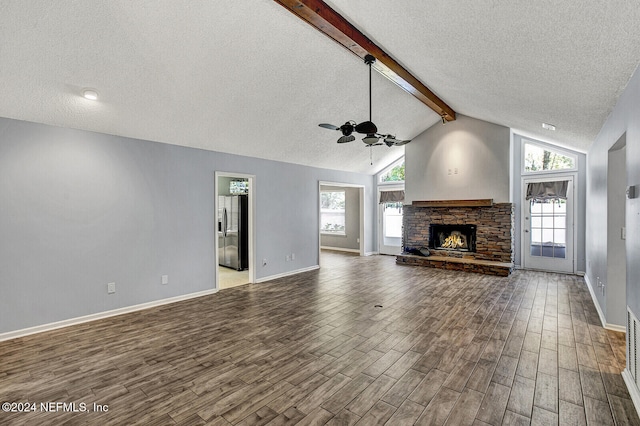 unfurnished living room with plenty of natural light, dark hardwood / wood-style flooring, and a textured ceiling