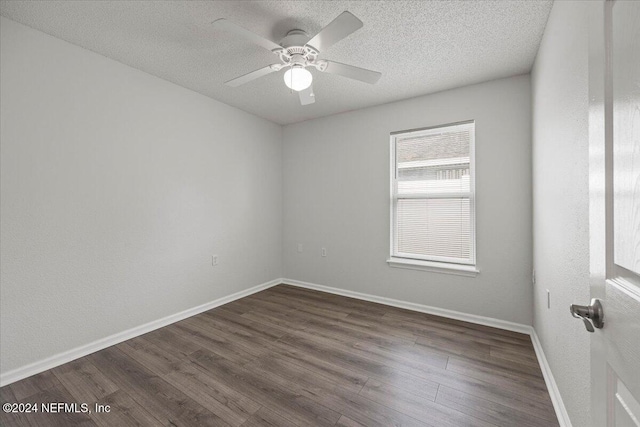 unfurnished room featuring ceiling fan, dark wood-type flooring, and a textured ceiling