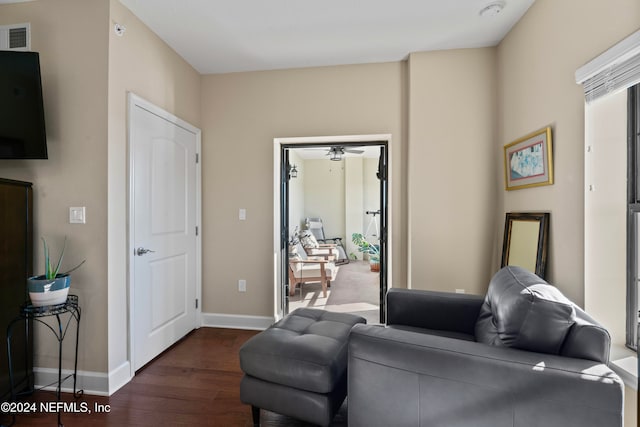 living room featuring ceiling fan and dark hardwood / wood-style flooring