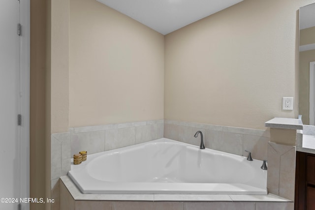 bathroom with vanity and a relaxing tiled tub