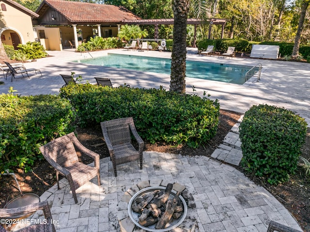 view of swimming pool with a patio area and an outdoor fire pit