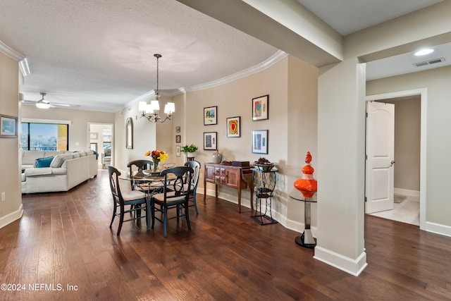 dining space with a textured ceiling, ceiling fan with notable chandelier, dark hardwood / wood-style floors, and ornamental molding