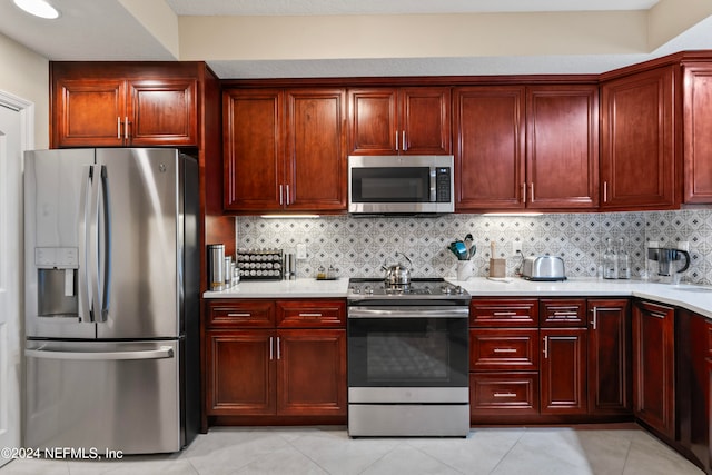 kitchen with decorative backsplash, light tile patterned floors, and appliances with stainless steel finishes