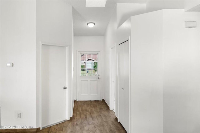 corridor featuring wood-type flooring and a textured ceiling