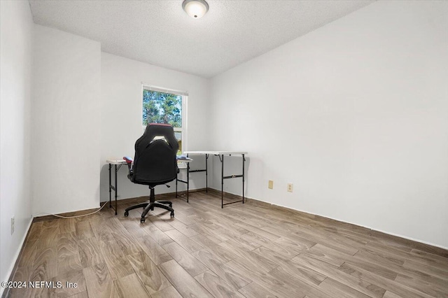 home office featuring a textured ceiling and light wood-type flooring