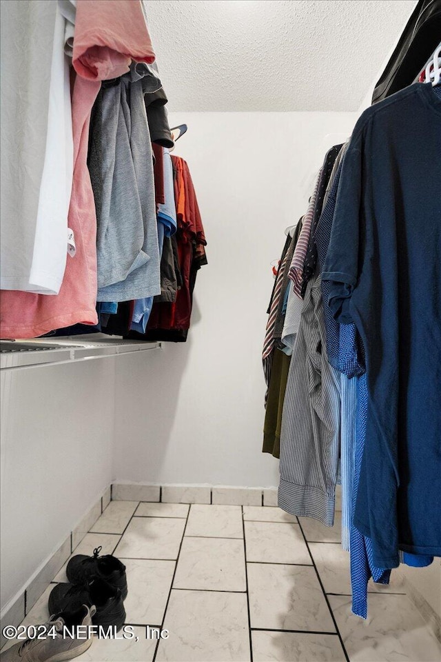 walk in closet with light tile patterned floors