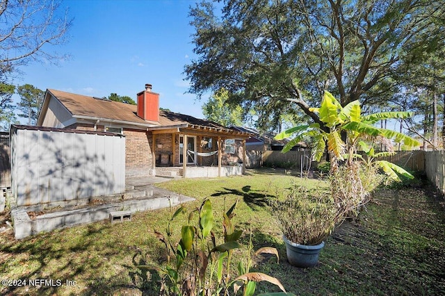 back of property with a patio area and a yard