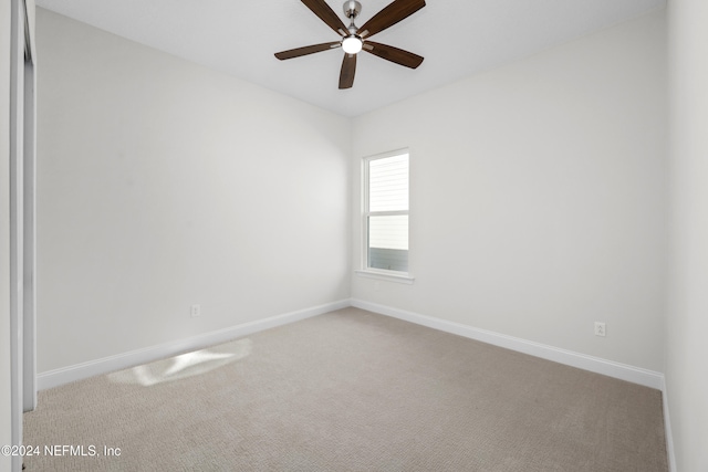 carpeted spare room featuring ceiling fan