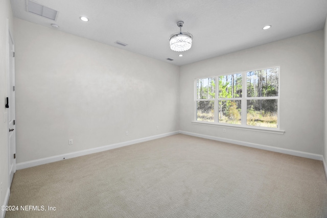 unfurnished room featuring light colored carpet