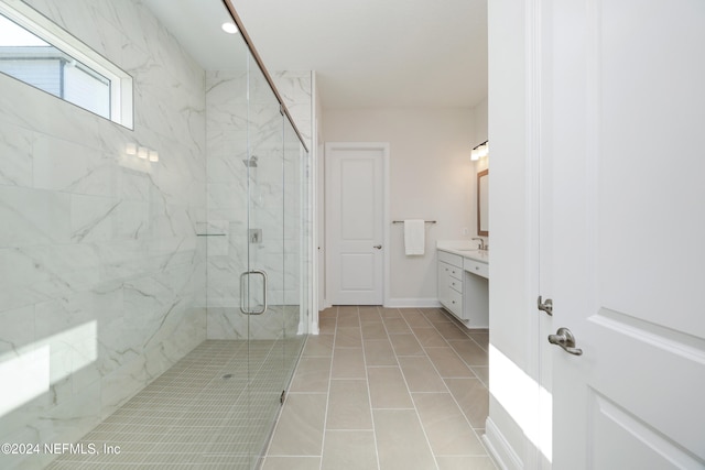 bathroom with tile patterned flooring, vanity, and walk in shower