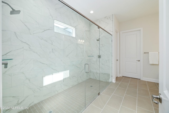 bathroom with tile patterned floors and a shower with door