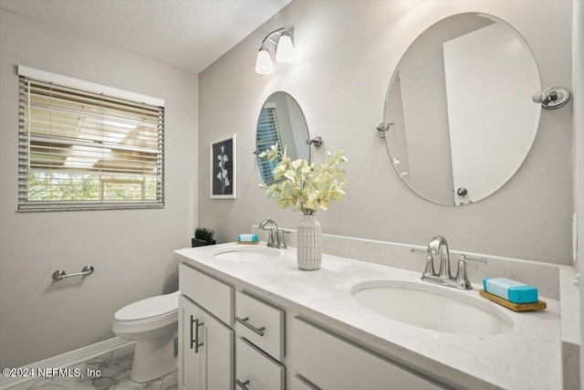 bathroom with vanity, a textured ceiling, and toilet