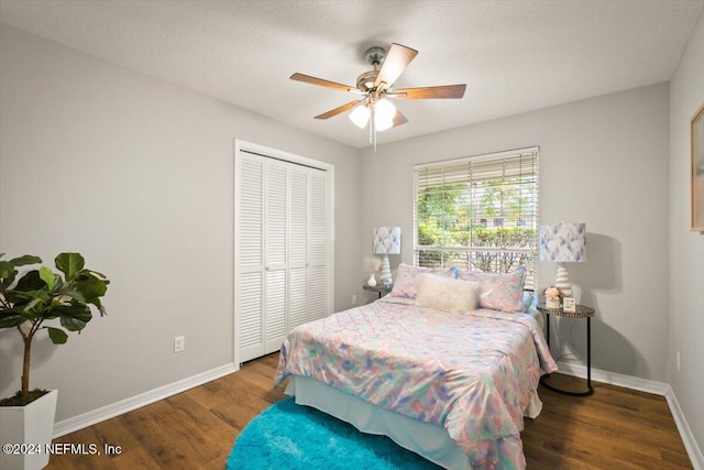 bedroom with ceiling fan, a closet, and dark wood-type flooring