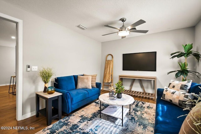 living room with ceiling fan, wood-type flooring, and a textured ceiling