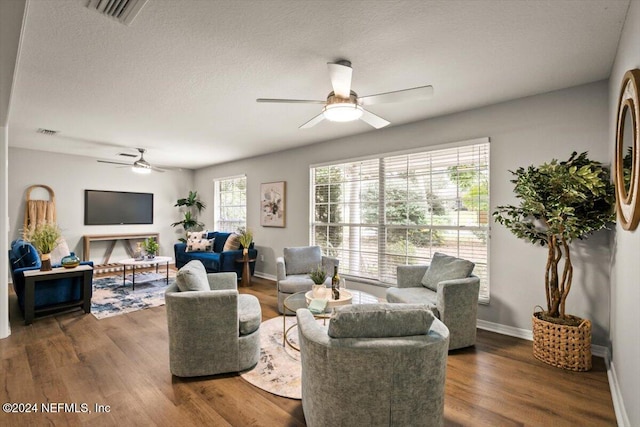 living room with dark hardwood / wood-style flooring, plenty of natural light, and a textured ceiling