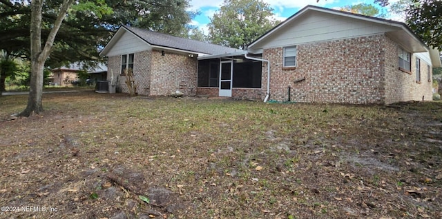 rear view of property featuring a sunroom and cooling unit