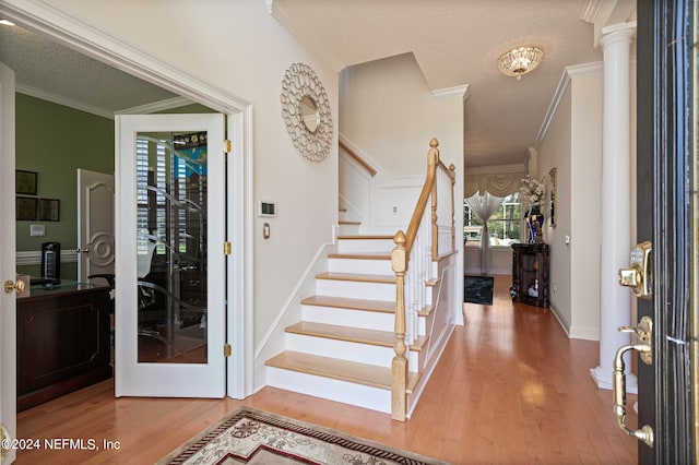 foyer entrance featuring crown molding, a textured ceiling, and hardwood / wood-style flooring