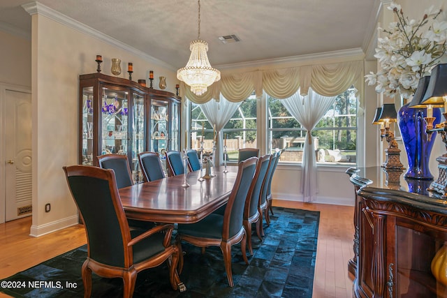 dining area featuring a textured ceiling, hardwood / wood-style flooring, crown molding, and a notable chandelier