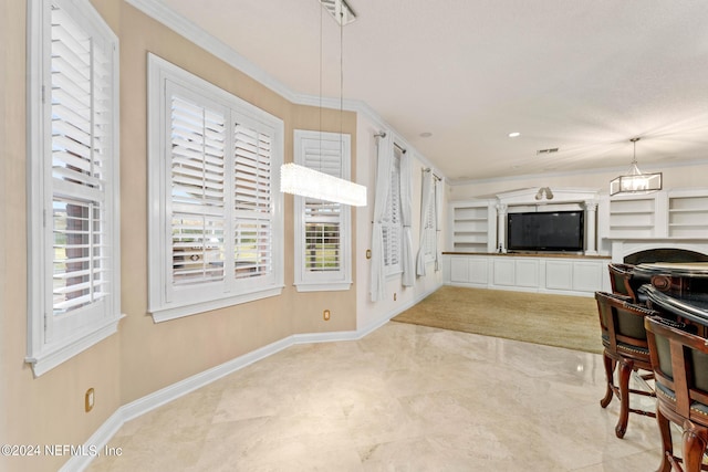 living room with built in features, a notable chandelier, and ornamental molding