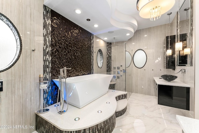 bathroom featuring separate shower and tub, vanity, and tile walls