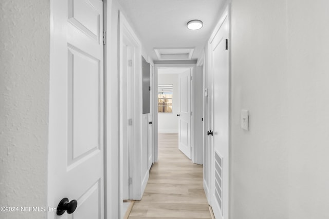 hallway with light hardwood / wood-style floors