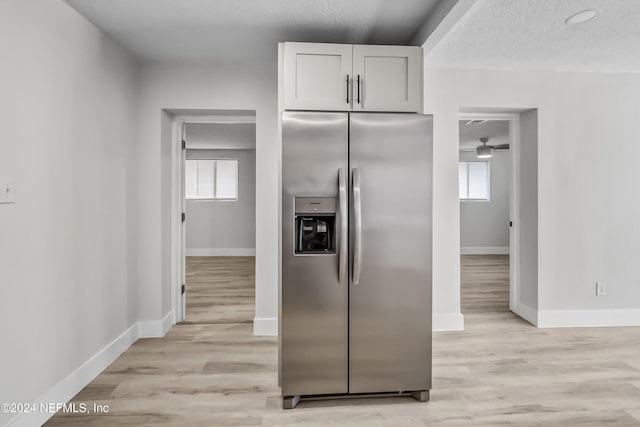 kitchen featuring white cabinets, light hardwood / wood-style floors, stainless steel fridge with ice dispenser, and a textured ceiling