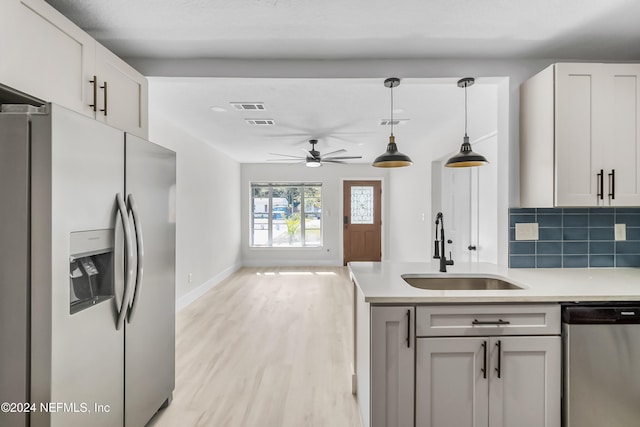 kitchen featuring ceiling fan, sink, stainless steel appliances, tasteful backsplash, and white cabinets